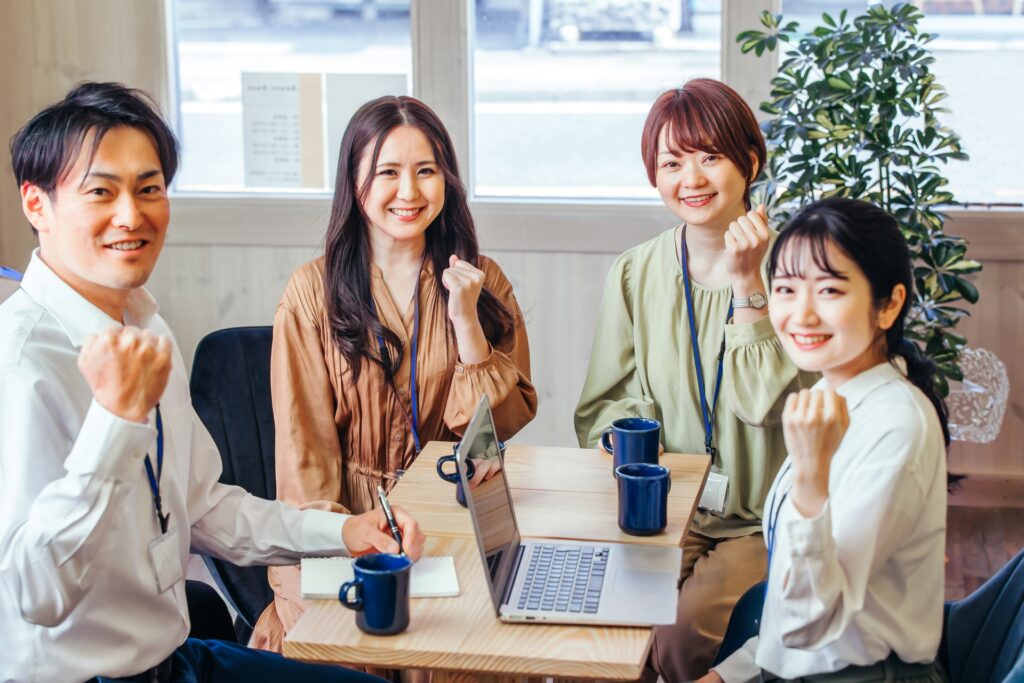 打ち合わせしてガッツポーズする男女